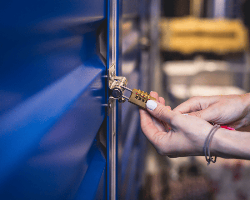a woman locking the storage with padlock