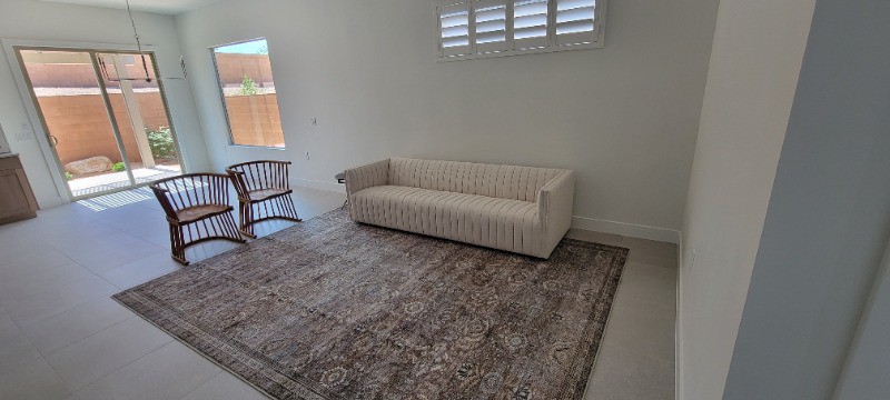 a white living room with two wooden chairs and white sofa